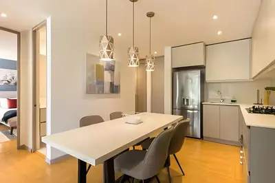 a kitchen and dining room with a white table and chairs at Provenza Life 501 - Apt in the heart of Provenza in El Poblado