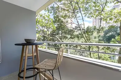 a balcony with two chairs and a table and a window at Provenza Life 501 - Apt in the heart of Provenza in El Poblado