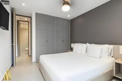 a bedroom with a large white bed and a bathroom at Provenza Life 703 - Secure/bright apt/priv balcony in El Poblado