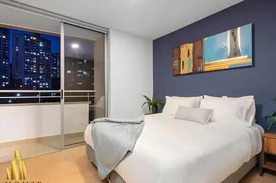 a bedroom with a large white bed and a window at Provenza Life 901 - Serene/family-friendly loft in El Poblado