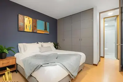 a bedroom with a large white bed and blue walls at Provenza Life 901 - Serene/family-friendly loft in El Poblado
