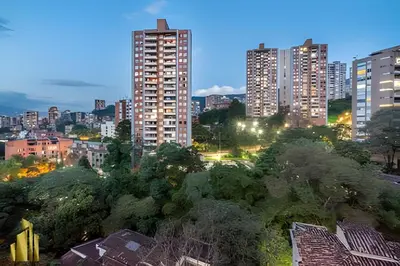 a city skyline with tall buildings and trees at night at Provenza Life 901 - Serene/family-friendly loft in El Poblado