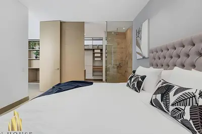 a bedroom with a large white bed with black and white pillows at Q Tower 506 - Bright & Chic Loft In Poblado in Las Palmas