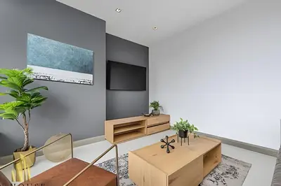 a living room with a tv on a wall at Q Tower 506 - Bright & Chic Loft In Poblado in Las Palmas