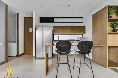 a kitchen with two black chairs and a table at Q Tower 506 - Bright & Chic Loft In Poblado in Las Palmas