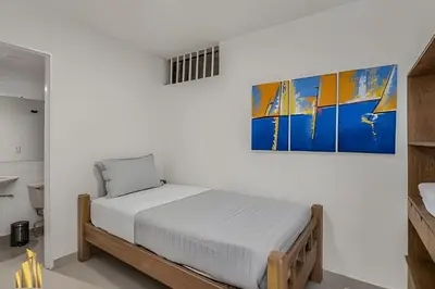 a bedroom with a bed and a painting on the wall at San Angel 205-Familiar & Trendy apt near Provenza in El Poblado