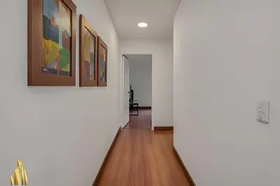 a hallway with white walls and paintings on the wall at San Angel 205-Familiar & Trendy apt near Provenza in El Poblado