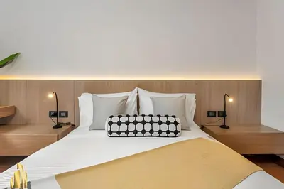 a bed with a black and white pillow on it at San Angel 205-Familiar & Trendy apt near Provenza in El Poblado