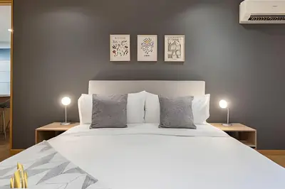 a bedroom with a large white bed with three pictures on the wall at Santacoloma 407 Apto tranquilo con vistas verdes. AC in El Poblado