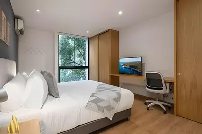 a bedroom with a bed and a desk and a computer at Santacoloma 407 Apto tranquilo con vistas verdes. AC in El Poblado