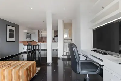 a living room with a television and a desk with a chair at Santiago De Bagatela 1104 - Spacious apt Poblado in Envigado
