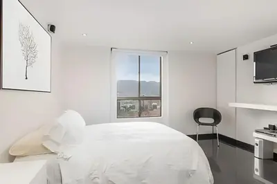 a white bedroom with a bed and a window at Santiago De Bagatela 1104 - Spacious apt Poblado in Envigado
