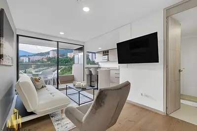 a living room with white furniture and a television at Scala 1901 - Serene apt/balcony/deluxe furniture in Sabaneta