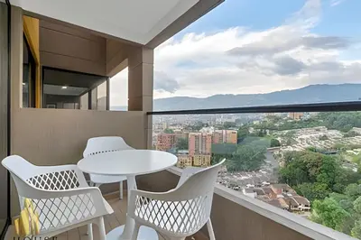 a balcony with a table and chairs and a view at Scala 1901 - Serene apt/balcony/deluxe furniture in Sabaneta