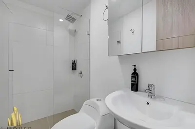 a white bathroom with a toilet and a sink at Scala 1901 - Serene apt/balcony/deluxe furniture in Sabaneta