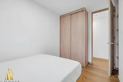 a bedroom with a white bed and a wooden cabinet at Scala 1901 - Serene apt/balcony/deluxe furniture in Sabaneta