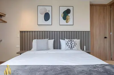a bedroom with a large white bed with two pillows at Solei Loft 201 - Luxe Stay in El Poblado in El Poblado