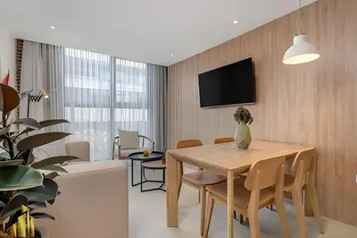 a dining room with a table and a tv on a wall at Solei Loft 201 - Luxe Stay in El Poblado in El Poblado