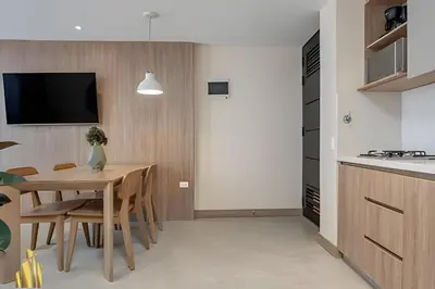 a kitchen and dining room with a table and a tv at Solei Loft 201 - Luxe Stay in El Poblado in El Poblado