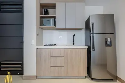 a kitchen with a stainless steel refrigerator and cabinets at Solei Loft 201 - Luxe Stay in El Poblado in El Poblado