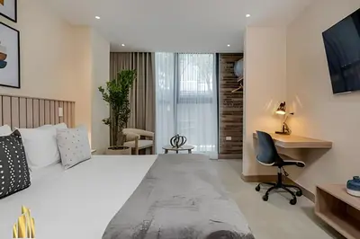 a bedroom with a large bed with a desk and a chair at Solei Loft 202 - Chic Studio with AC in El Poblado