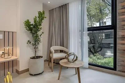 a room with a chair and a table and a window at Solei Loft 202 - Chic Studio with AC in El Poblado