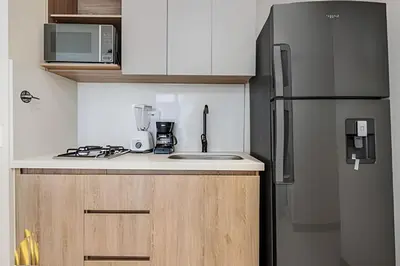 a small kitchen with a refrigerator and a sink at Solei Loft 301 - Location/Trendy Jacuzzi Living in El Poblado