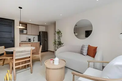 a living room with a white couch and a table at Solei Loft 301 - Location/Trendy Jacuzzi Living in El Poblado