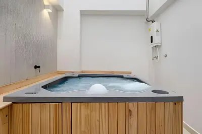 a jacuzzi tub in the middle of a bathroom at Solei Loft 302 - Elegant Oasis: Loft/Jacuzzi/AC in El Poblado