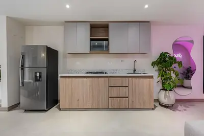 a kitchen with a stainless steel refrigerator and cabinets at Solei Loft 302 - Elegant Oasis: Loft/Jacuzzi/AC in El Poblado