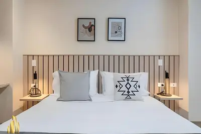a bedroom with a white bed with three pictures on the wall at Solei Loft 303 - Modern Loft in Poblado with AC in El Poblado