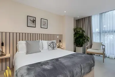 a bedroom with a large bed and a chair at Solei Loft 303 - Modern Loft in Poblado with AC in El Poblado