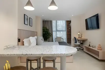a bedroom with a bed and a table with chairs at Solei Loft 303 - Modern Loft in Poblado with AC in El Poblado