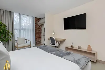 a hotel room with a bed and a television at Solei Loft 303 - Modern Loft in Poblado with AC in El Poblado