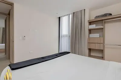 a bedroom with a white bed and a refrigerator at Solei Loft 401 - Elegance & Comfort /AC in Poblado in El Poblado