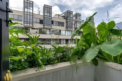a building with windows and plants in front of it at Solei Loft 401 - Elegance & Comfort /AC in Poblado in El Poblado