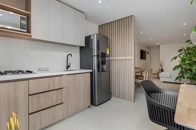 a kitchen with a stainless steel refrigerator and a table at Solei Loft 401 - Elegance & Comfort /AC in Poblado in El Poblado