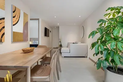 a dining room with a wooden table and a potted plant at Solei Loft 401 - Elegance & Comfort /AC in Poblado in El Poblado