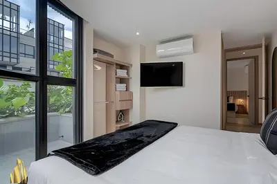 a bedroom with a white bed and a large window at Solei Loft 401 - Elegance & Comfort /AC in Poblado in El Poblado