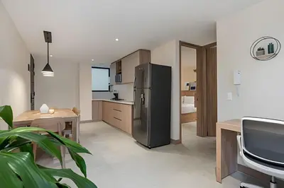 a kitchen with a stainless steel refrigerator and a tv at Solei Loft 402 - Espacious & bright apt with AC in El Poblado