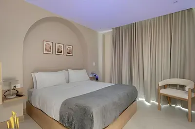 a bedroom with a large bed and a chair at Solei Loft 402 - Espacious & bright apt with AC in El Poblado