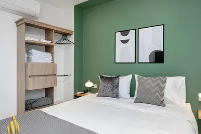 a bedroom with a white bed and a green wall at Solei Loft 502 - Calm & cozy in Manila Poblado/AC in El Poblado