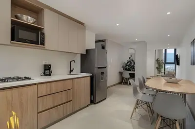 a kitchen with a table and some chairs and a counter at Solei Loft 502 - Calm & cozy in Manila Poblado/AC in El Poblado