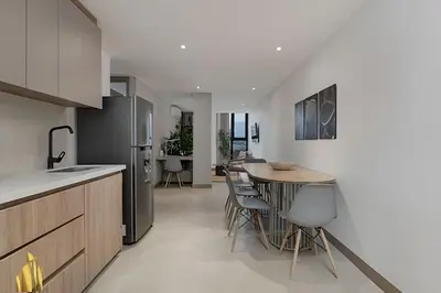 a kitchen with a wooden table and a kitchen with a refrigerator at Solei Loft 502 - Calm & cozy in Manila Poblado/AC in El Poblado