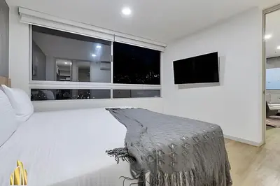 a white room with a large window and a couch at Urbano2205-Serenidad y fitness. Apt- piscina/gym in El Poblado