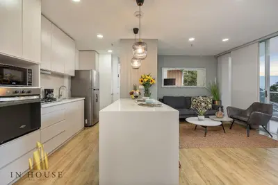 a kitchen and living room with a white counter top at Urban 701-Apt relajante con piscina, jacuzzi y gym in El Poblado