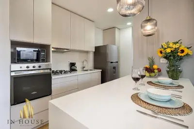 a white kitchen with a table with glasses of wine at Urban 701-Apt relajante con piscina, jacuzzi y gym in El Poblado