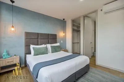 a bedroom with a large bed and a blue wall at Urban 701-Apt relajante con piscina, jacuzzi y gym in El Poblado