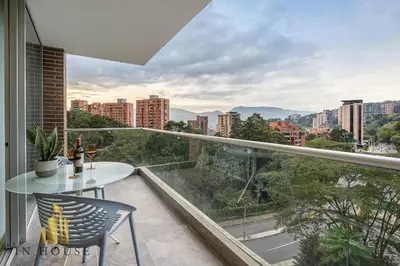 a balcony with a table and chairs and a view of the city at Urban 701-Apt relajante con piscina, jacuzzi y gym in El Poblado