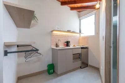 a small kitchen with a sink and a stove at Spacious Laureles Apt-SuperHost-AC-WIFI in Medellín